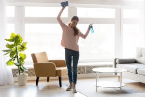 Woman smiling and cleaning living room