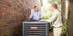 Service technician discussing Goodman AC repair with homeowner