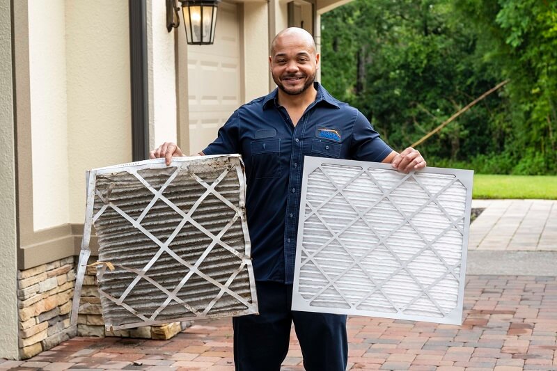 Strad Services Technician holding new and old air filters