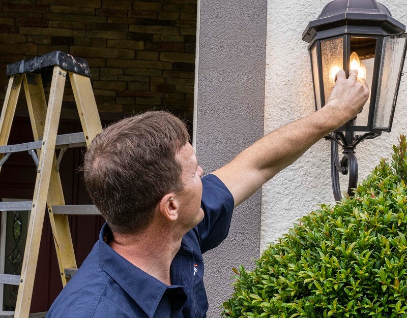 Strada employee checking outdoor light fixture