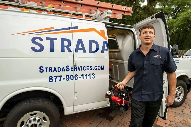 Técnico de servicio de Strada saliendo del camión con una caja de herramientas
