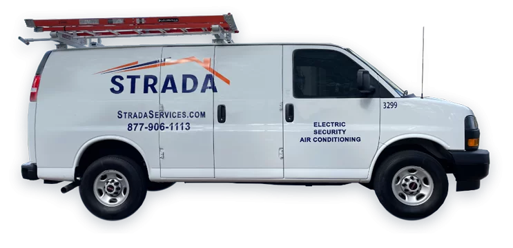 Una furgoneta utilitaria blanca de Strada Services tiene una escalera roja en el techo. En la furgoneta se lee: &quot;Electricidad, Seguridad, Aire Acondicionado&quot;.