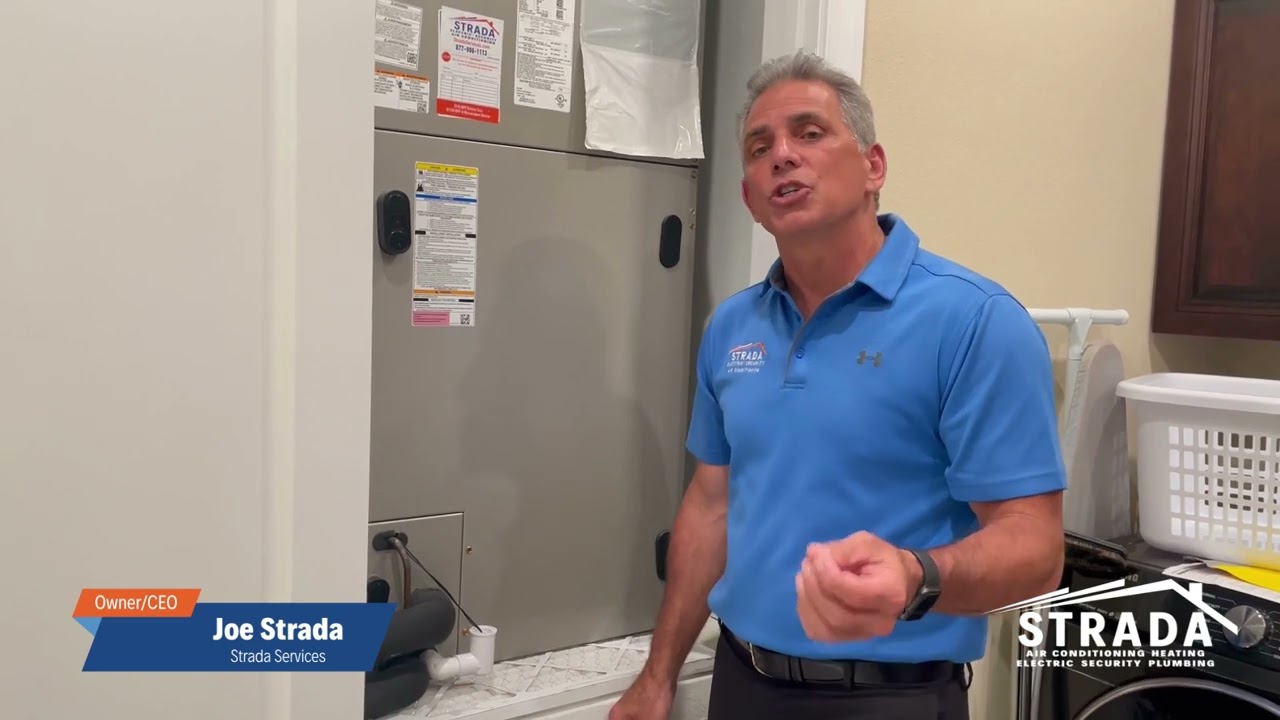 The owner of Strada Services, Joe Strada, is standing in a laundry room talking for a YouTube video.